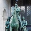 Statue of Roosevelt on horseback flanked by African and Native American