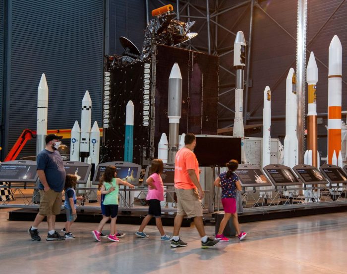 Family group walks past rocket display