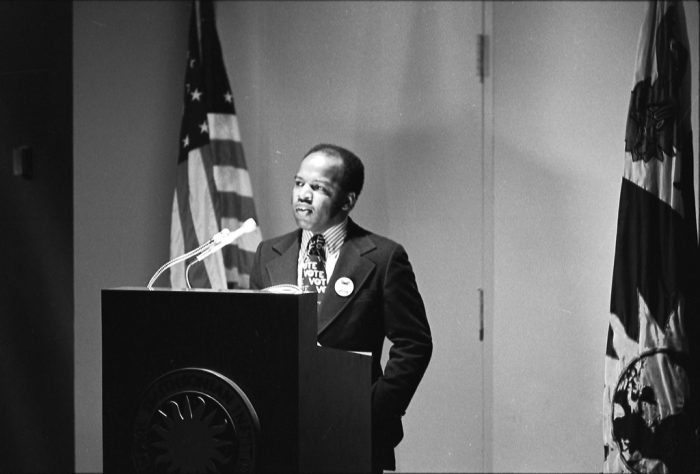 Black and white photo of Lewis at podium