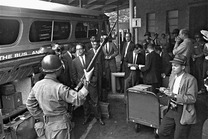 Men in suits boarding bus with National Guar din foreground