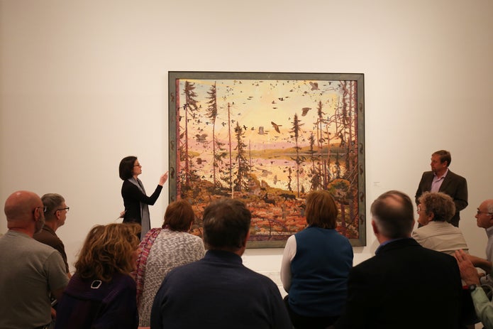 People listening to curator describe painting