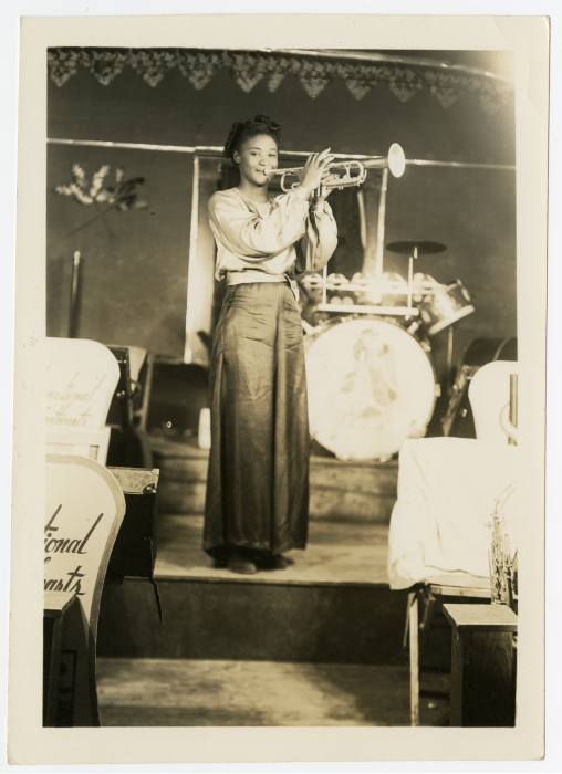 B&W photo of stylish Black woman holding trumpet