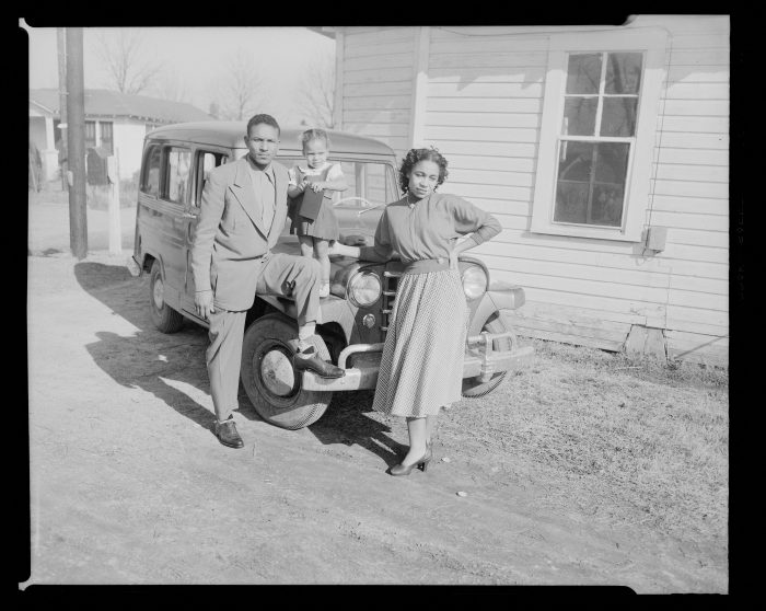 Family posing with car