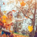 Young girl playing in fall leaves