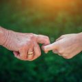 Older person holding childs hand