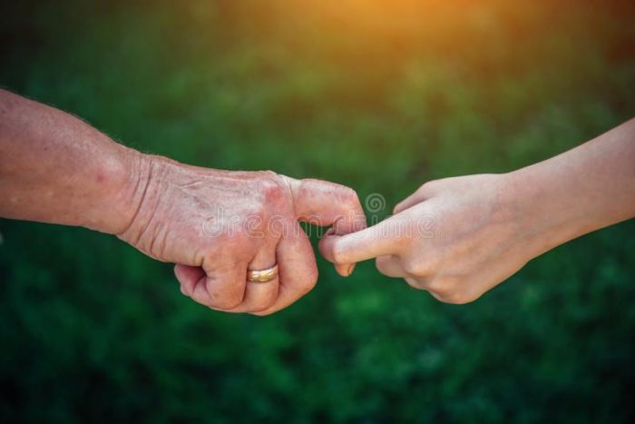 Older person holding childs hand