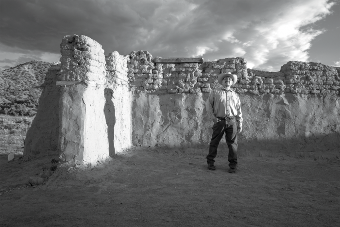 Native American man standing in pueblo ruins