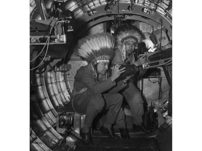 Horace Poolaw with feathered war bonnet inside WWI aircraft