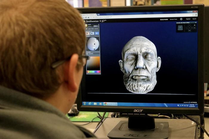 person looking a laptop screen showing 3D image of Abraham Lincoln