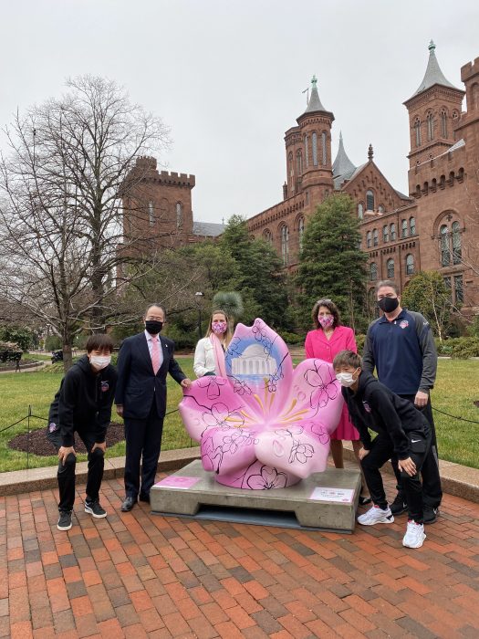 Group gathered around cherry blossom sculpture in Haupt Garden