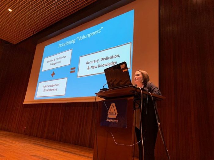 Caitlin at podium in front of presentation screen