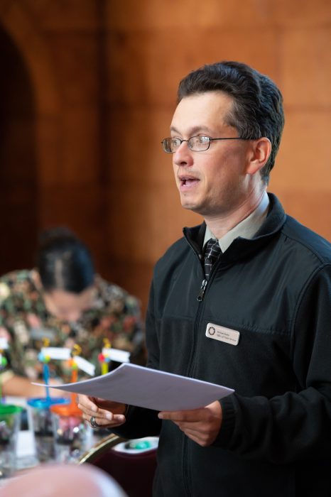 Rubin holding paper and addressing audience