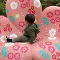 Young boy sitting in cherry blossom sculpture