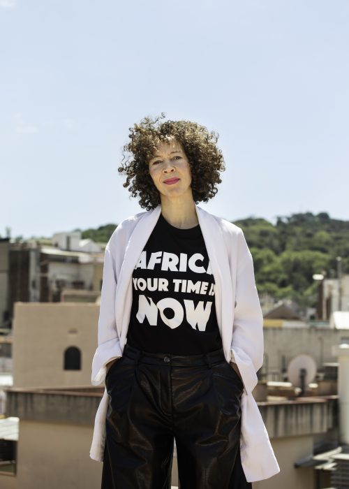 Blankenship on a roodtop wearing Tshirt saying Africa, your time is now