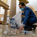 Rep Kim picks up water bottles and other litter from floor of Capitol