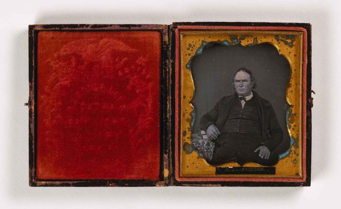 Portrait of man with books in red velvet case