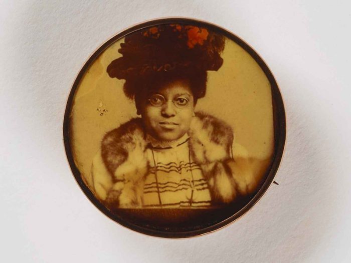 Portrait of African American woman wearing glasses and a fancy hat