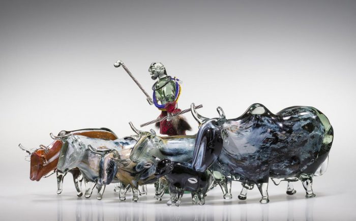 Glass sculpture of herder and cattle