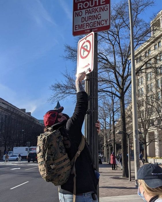 Volunteer removing stickers from sign