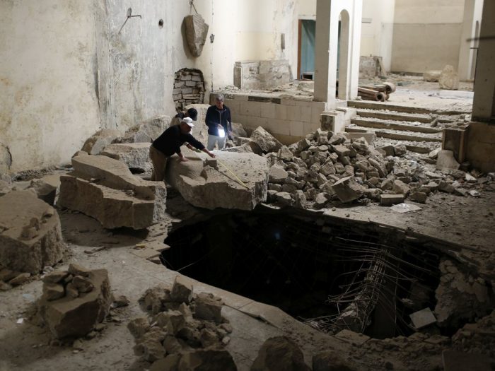 Workers search debris