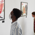 Museum visitor wearing facemask, looking at art in gallery