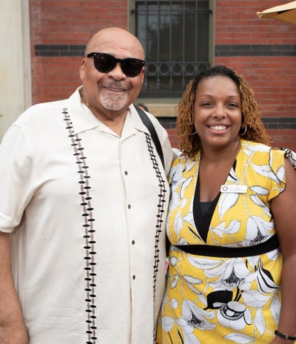 Sherri Wheeler poses with volunteer Albert Howard with A&I building in background