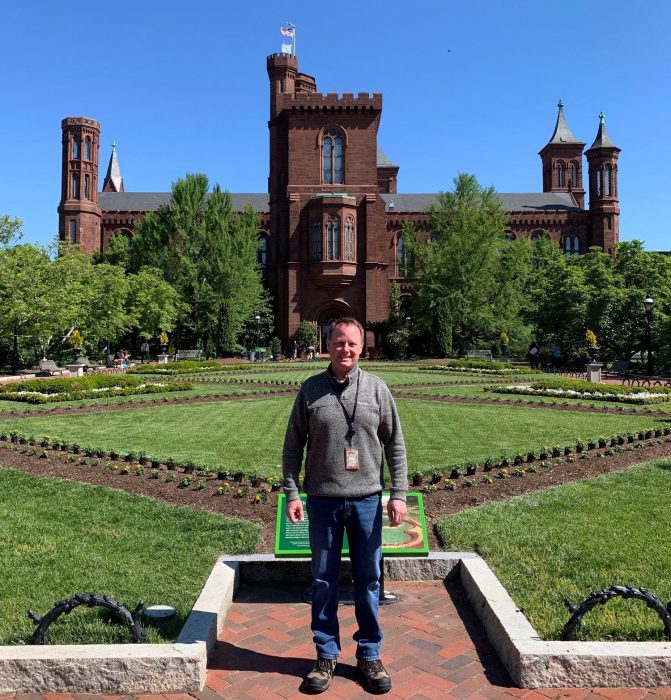 Schneider stands in front of the parterre in the Enid Haupt Garden