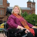 Beth Ziebarth in wheelchair poses in Haupt Garden