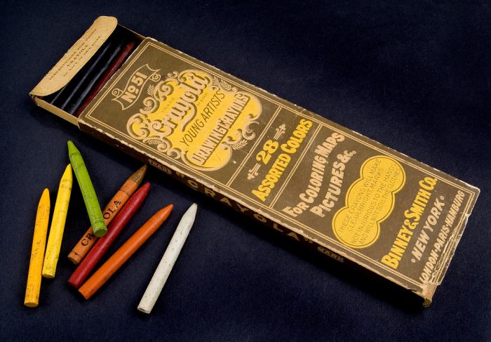 Early Crayola box and crayons photographed against black background