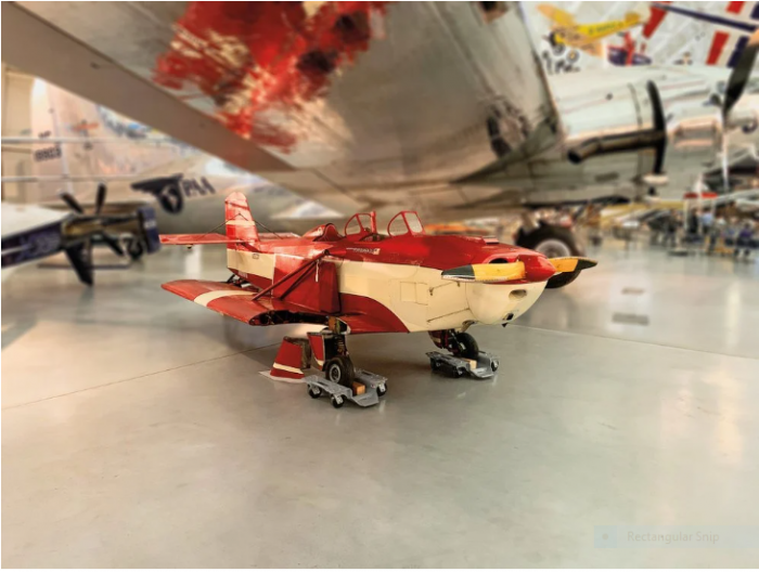 Red airplane parked in hangar