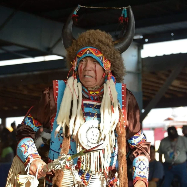 Jim Red Eagle in ceremonial dress wearing buffalo horn headdress