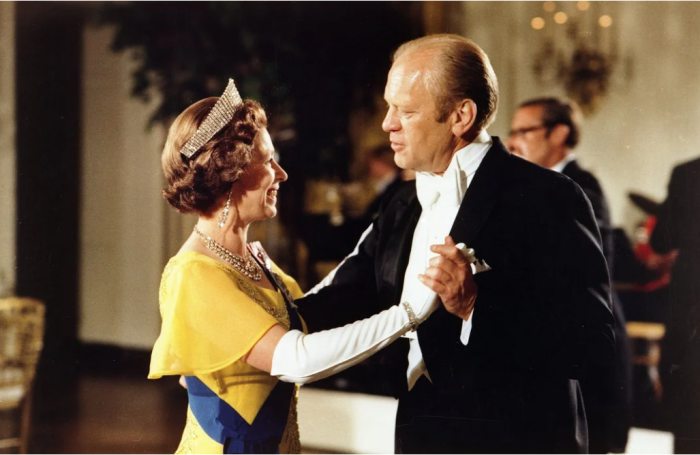 Queen in yellow dress dances with President Gerald Ford in white tie