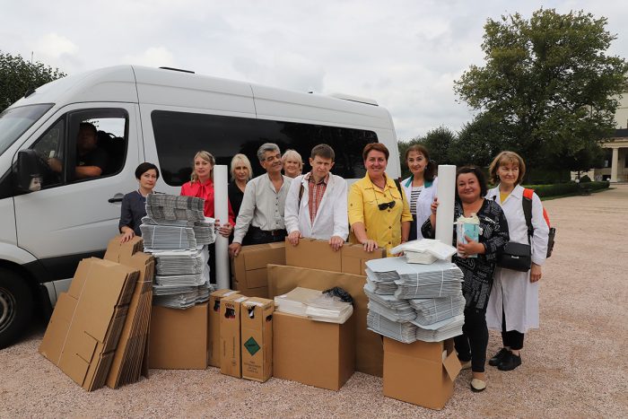 Conservators pose with boxes and packaging materials