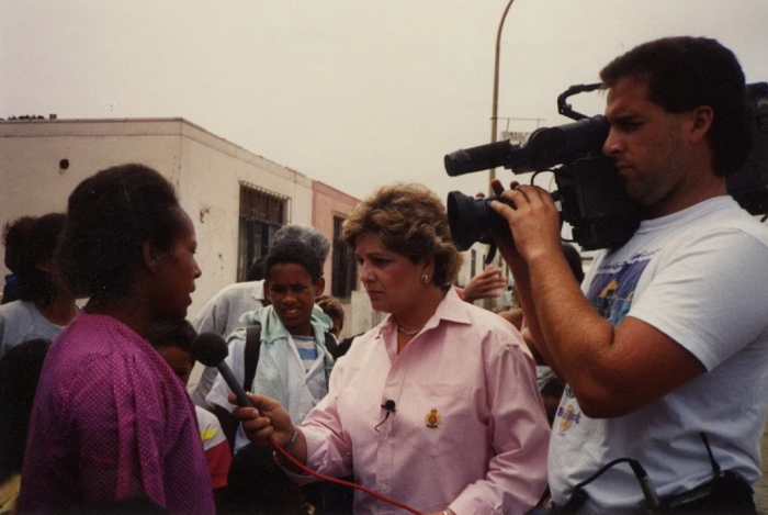 Reporter and cameraman interviewing woman in the field