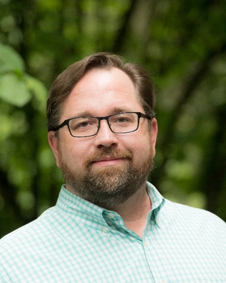 Head shot of Bob Lee against leafy background