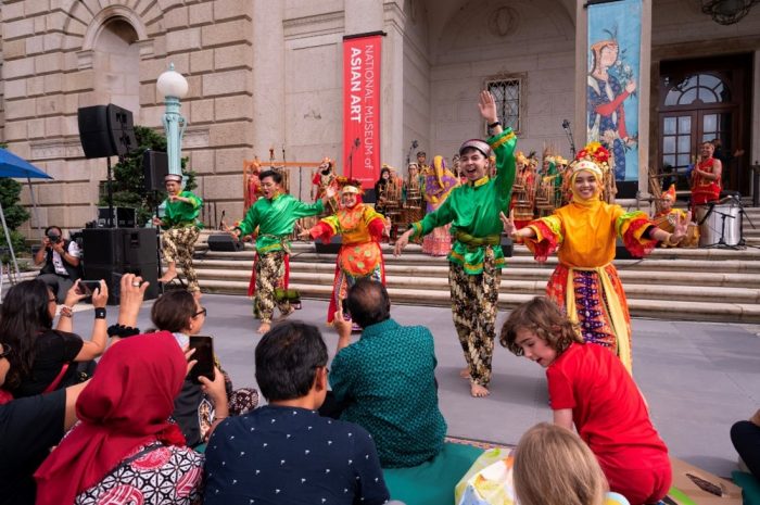 Colorful dancers performing in front of Freer Gallery