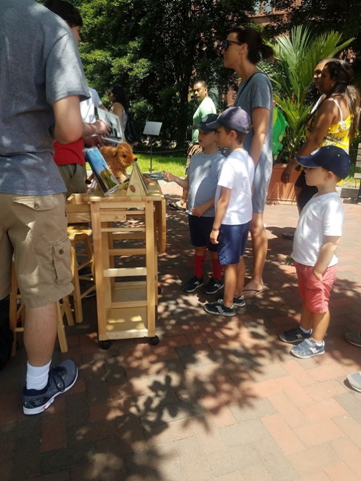 Children gather around bison in our backyard cart