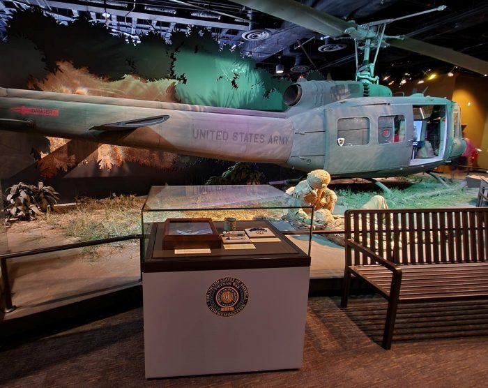 Diorama display of US Army helicopter and soldier assisting wounded man