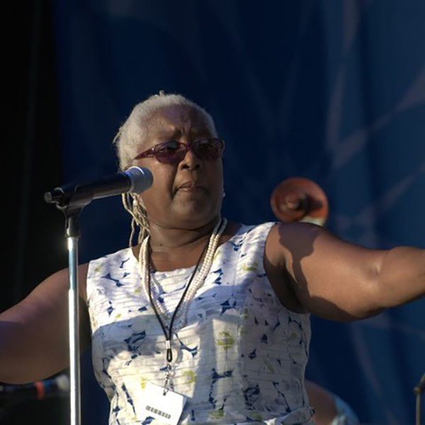 Older Black woman with microphone on stage