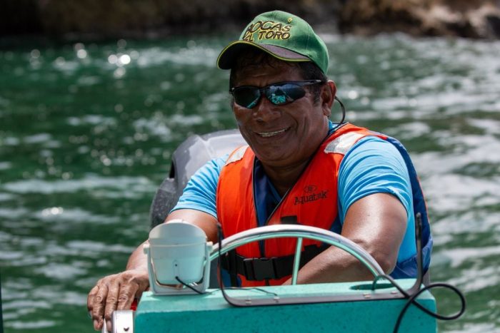 Close up of Castillo wearing Bocas del Toro cap steering personal water craft