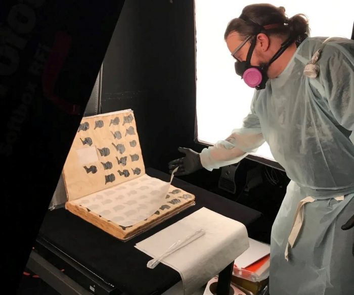 Technician wears protective gear while digitizing toxic album