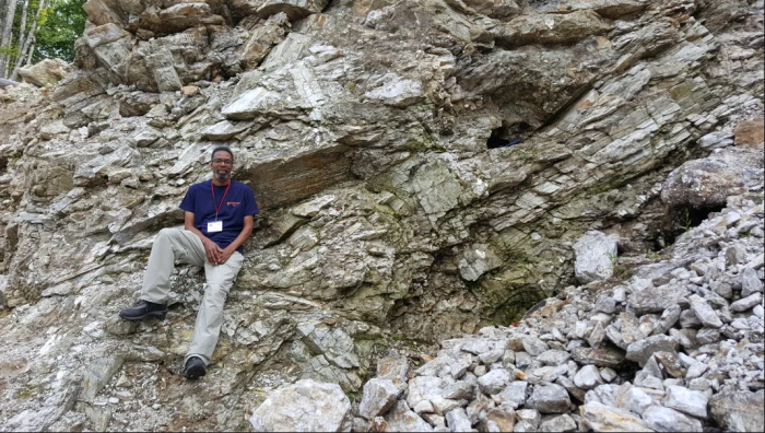 Mike Wise leaning against rock formation