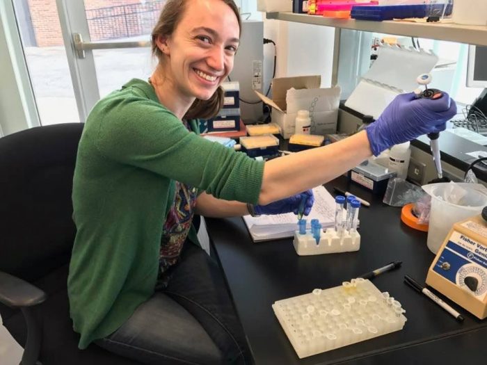 Alyssa Kaganer smiles at camera while working in the lab