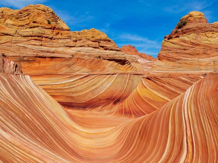 Striated rock formations against a bright blue sky