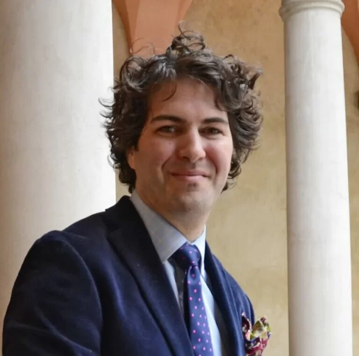 Head shot of Adam Rozan, white columns in the background