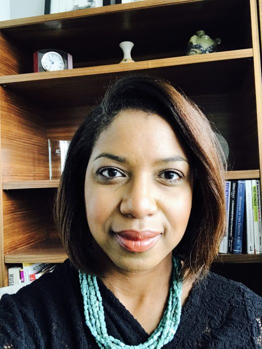 Head shot of Shanita Brackett in front of bookshelves