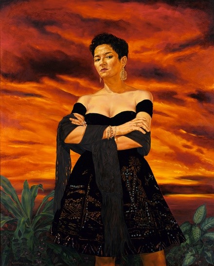 Portrait of woman in black dress with arms folded against a blazing sunset sky