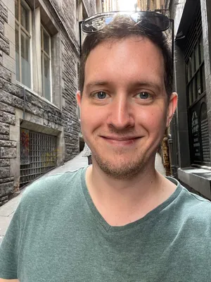 Headshot of Mike Bock with old city street in background