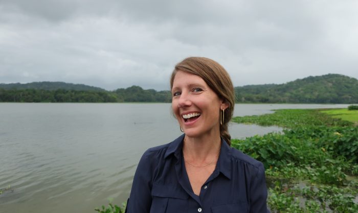 Erin Spear laughs while standing in front of body of water in Panama