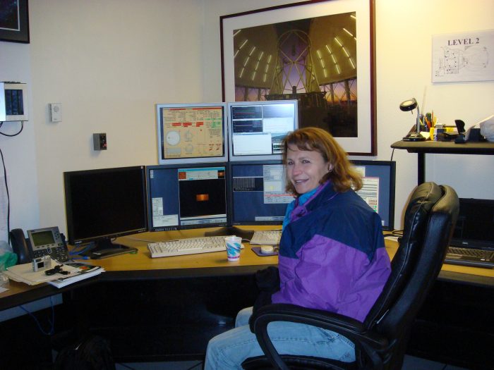 Collins sitting at desk with multiple monitors